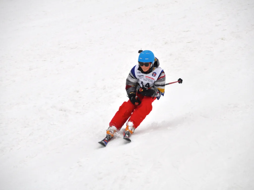 Skifahrer in rot-blauer Kleidung zieht einen Schwung.